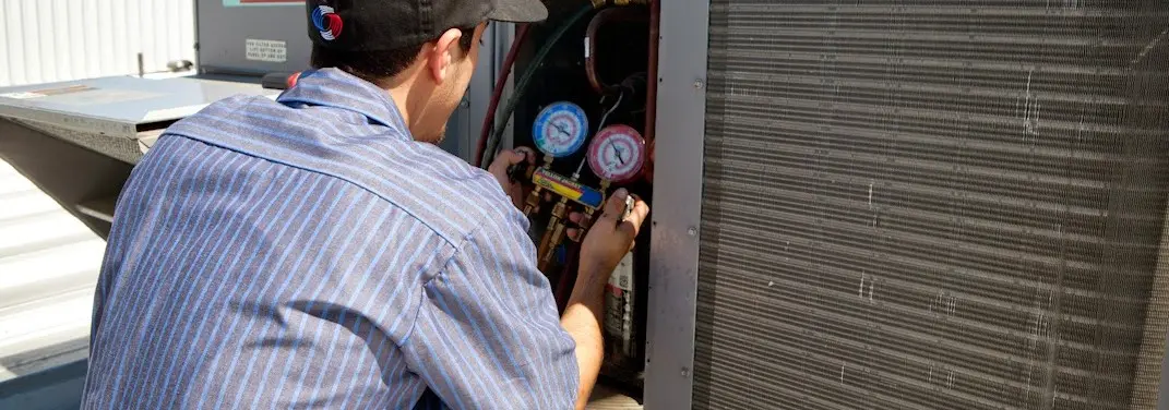 HVAC technician servicing a condenser unit in Sierra Vista Southeast